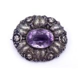 An Arts and Crafts silver and amethyst brooch, the central oval cut amethyst 22 x 16mm, in a