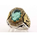 A gentleman's emerald and diamond dress ring, the central emerald 12.9 x 8.8 x 3.4, above a frame of