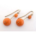 A pair of coral and diamond earrings, each large circular coral drop inset with a small rose cut,