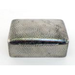 A hammered pewter cigarette box stamped "TUDRIC PEWTER", cedarwood-lined, 13 cm. long. Small ding to