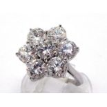 An impressive diamond daisy cluster dress ring, composed of seven uniform brilliants totalling