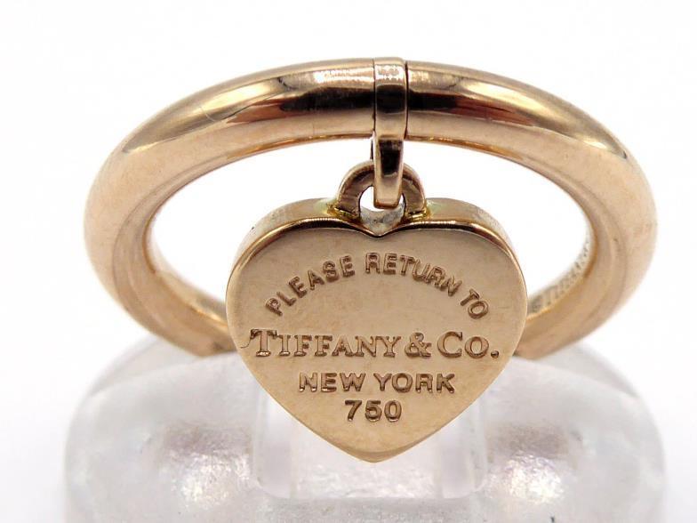 TIFFANY & Co., an 18 carat rose gold ring, suspended with a signed heart tag, finger size J, 5.