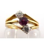 A garnet and diamond ring, the central round cut almandine obliquely set either side with two