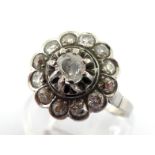 A platinum and diamond cluster ring, the central brilliant approx. 0.23 carat, claw set above a