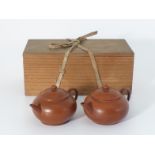 Two similar Yixing ware tea pots and covers in Japanese wood box, with compressed globular bodies,