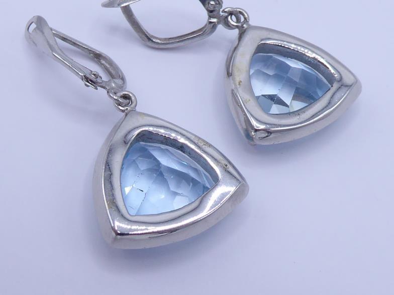 A pair of blue topaz and diamond earrings, the triangular cushion cut topaz each 13mm wide, in a - Image 2 of 3