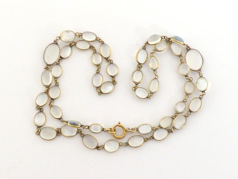 A moonstone necklace, composed of graduated oval cabochons, each spectacle set, to a bolt ring