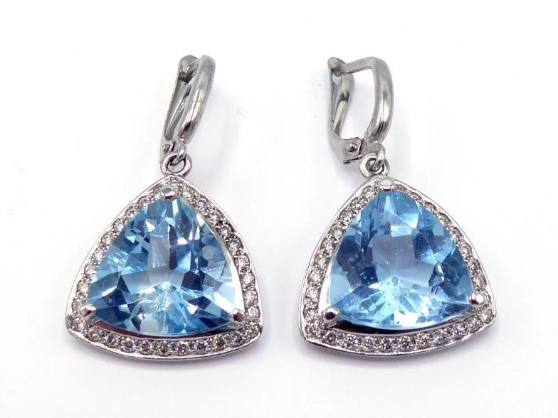 A pair of blue topaz and diamond earrings, the triangular cushion cut topaz each 13mm wide, in a