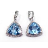 A pair of blue topaz and diamond earrings, the triangular cushion cut topaz each 13mm wide, in a