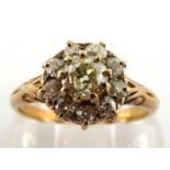 A late 19th/early 20th century diamond cluster ring, the daisy cluster centred on a tinted old