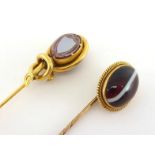 A Victorian 18 carat gold and banded sardonyx stick pin, the oval cabochon stone in a wirework