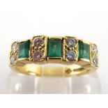 An 18 carat gold, diamond and emerald ring, composed of alternate emerald cut emeralds and pairs