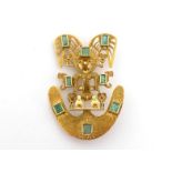 An emerald brooch, designed as an Aztec figure, mounted overall with collet set emeralds, stamped '