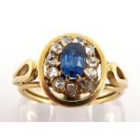 A sapphire and diamond cluster ring, the central oval cut sapphire 6.4 x 4.2, in a surround of