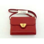 A Gianfranco Ferre red leather handbag with goldtone hardware, still with shop tag. Labelled