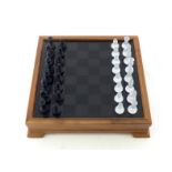 A modern table chess set, the hardwood case with glass cover reversible and frosted to form the