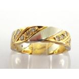 An 18 carat two colour gold and diamond ring, pave set with diagonal bands of brilliants,