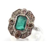 An emerald and diamond plaque ring, the central emerald cut emerald 7.5 x 5.5mm, in a surround of