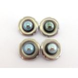 A pair of cultured pearl cufflinks, each shaped square link (tests platinum) with a central 6.4mm