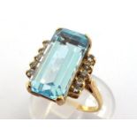 A blue topaz and diamond ring, the central emerald cut stone 16 x 8mm, bracketed with a row of small