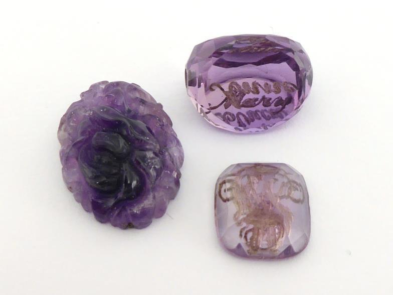 Three loose carved amethysts, including a swivel fob, a intaglio cut seal, and a foliate carved