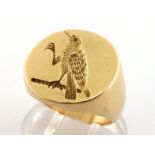 A gentleman's gold signet ring, the circular bezel intaglio cut with the crest of a raven, 17mm