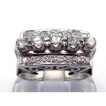 A diamond dress ring, the rectangular open work panel set with a claw set band of brilliants to
