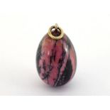 A late 19th century Russian rhodonite egg pendant, the polished rhodonite egg 28mm long, the white