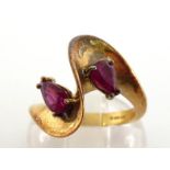 An 18 carat gold and ruby ring, the twist bezel set with two pear cuts, each 6 x 3mm, the shank