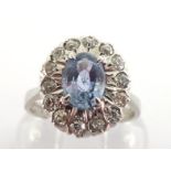 A sapphire and diamond cluster ring, the central oval cut sapphire 7 x 5mm, in a surround of