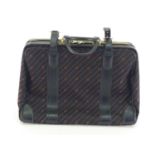 A vintage Gucci monogrammed suitcase travel bag with leather accents, goldtone buckles as stylised