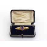 A 19th century amethyst and pearl (untested) bar brooch, the central oval cut amethyst 13 x 10mm,