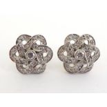A pair of diamond knot earrings, each open work knot pave set with single cut stones, a small