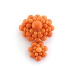 A coral brooch, composed of an oval four-tiered cluster, the central and largest bead 11mm diameter,