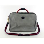 A stylish vintage Gucci monogrammed Carry on Travel bag with navy leather accents, striped handle