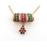 A sapphire, ruby and emerald pendant, the three panels pave set with alternate stones, to a