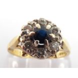 An 18 carat gold, sapphire and diamond cluster ring, the central round cut sapphire 4mm diameter, in