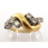 An 18 carat gold and diamond dress ring, the undulating bezel set either side with graduated