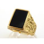 A gentleman's 18 carat gold signet ring, the central rectangular onyx tablet 13 x 9mm, to bark