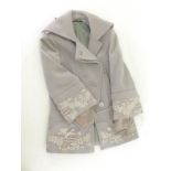 A grey ladys coat by Gucci with embroidered sleeves and waist, size 42.