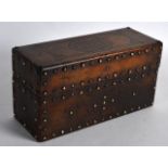 AN EARLY 20TH CENTURY TURKISH OR ISLAMIC LEATHER CASKET inset with brass stud work. 8.25ins wide.