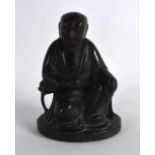 A CHINESE QING DYNASTY BRONZE FIGURE OF A SEATED SCHOLAR modelled upon a circular base. 5.25ins