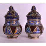 A PAIR OF EARLY 20TH CENTURY EUROPEAN FAIENCE GLAZED JARS AND COVERS painted with swirling motifs.