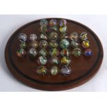 A GOOD SET OF SOLITAIRE MARBLES ON STAND of various sizes and internal decoration. Largest 1inch