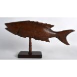AN UNUSUAL PITCAIRN ISLANDS CARVED WOOD MODEL OF A FISH supported upon a rectangular stand. 1Ft 2ins
