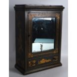 A LATE 19TH/20TH CENTURY CONTINENTAL BLACK LACQUERED CUPBOARD with mirrored front, painted with