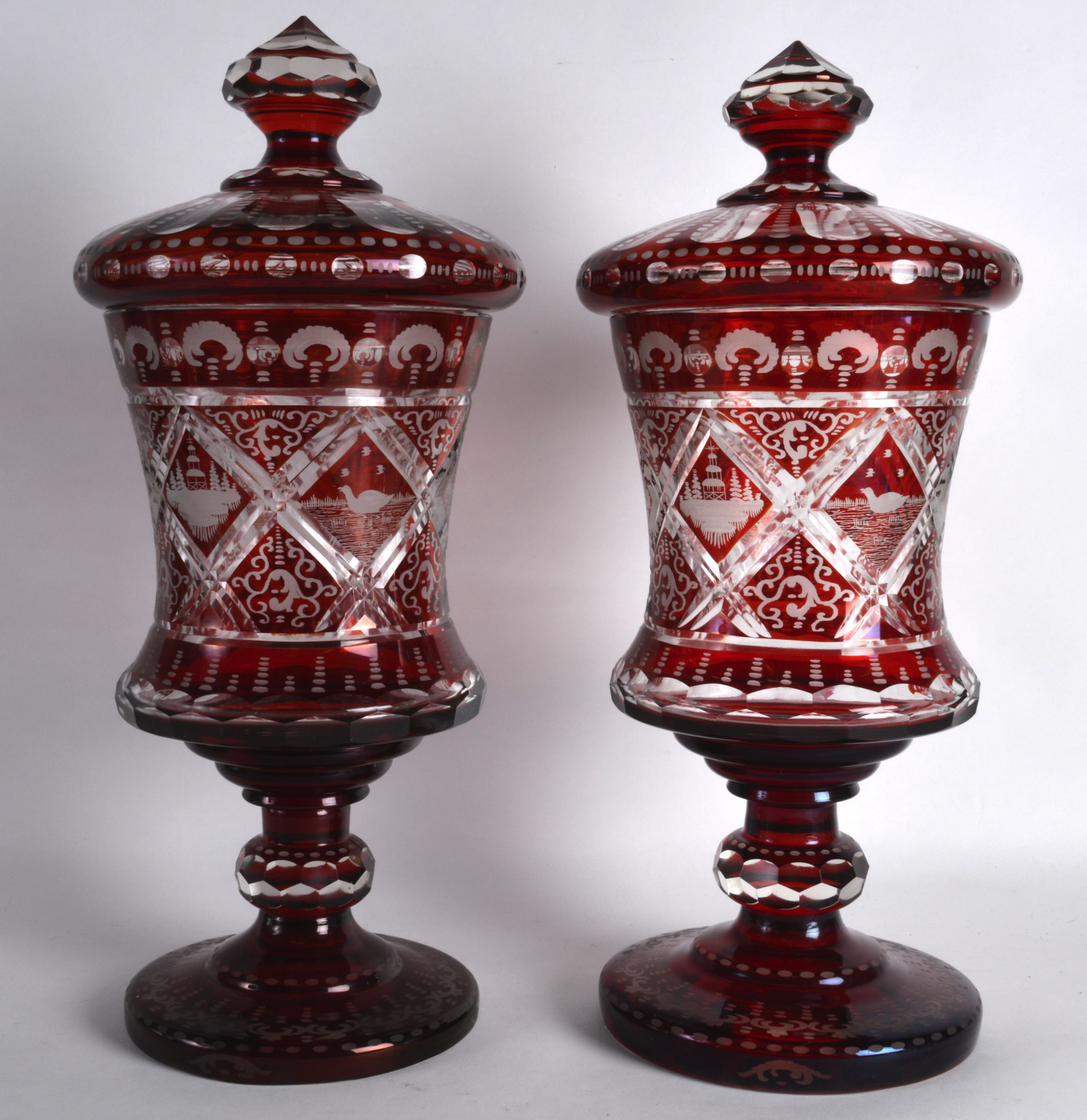 A FINE PAIR OF VERY LARGE BOHEMIAN RUBY GLASS GOBLETS AND COVERS engraved all over with ducks upon