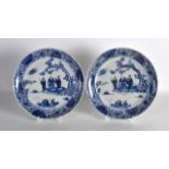 A PAIR OF 19TH CENTURY CHINESE BLUE AND WHITE PLATES painted with figures within landscapes. 9Ins