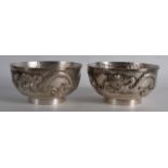 A GOOD PAIR OF 19TH CENTURY CHINESE EXPORT SILVER BOWLS decorated with dragons pursuing flaming
