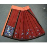 A LATE 19TH/20TH CENTURY CHINESE ORANGE SILKWORK SKIRT together with a similar ruby ground skirt,